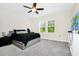 A bedroom with light gray walls, a large bed, and two windows with a view of the trees outside at 10070 Red Eagle Dr, Orlando, FL 32825