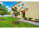 Home exterior with green door, well-manicured lawn, and stone walkway, with young trees adding to the landscape at 10070 Red Eagle Dr, Orlando, FL 32825