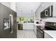 Modern kitchen showcasing stainless steel appliances, gray cabinets, wood-look tile flooring and an open layout at 10070 Red Eagle Dr, Orlando, FL 32825