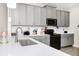 Modern kitchen featuring gray cabinets, quartz countertops, stainless steel appliances, and wood-look tile floors at 10070 Red Eagle Dr, Orlando, FL 32825