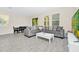 Cozy living room with a comfortable gray sectional sofa, modern white table and gray wood-look tile flooring at 10070 Red Eagle Dr, Orlando, FL 32825