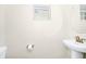 Well-lit powder room featuring a pedestal sink, round mirror, and modern fixtures at 10070 Red Eagle Dr, Orlando, FL 32825
