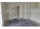 A bedroom featuring bare floors and walls, an open doorway, and a ceiling fan in the next room at 1020 E Main St, Haines City, FL 33844