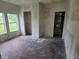 A bedroom featuring bare floors, a window view of the yard, and open closets at 1020 E Main St, Haines City, FL 33844