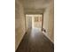 Hallway with dark wood floor, unfinished drywall, and a door leading to the back at 1020 E Main St, Haines City, FL 33844