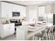 Modern kitchen featuring white cabinetry, stainless steel appliances, and a center island with seating at 117 Archer Ave, Lake Alfred, FL 33850