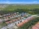 Aerial view of a community with lake, pool, tennis courts, and lush greenery at 1434 Pacific Rd, Kissimmee, FL 34759