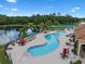 Aerial view of an inviting community pool with lounge chairs and lake views, perfect for relaxation at 1434 Pacific Rd, Kissimmee, FL 34759