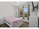 Bright bedroom featuring a twin bed, white dresser, and windows overlooking the property's landscaping at 1434 Pacific Rd, Kissimmee, FL 34759