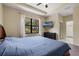 A carpeted bedroom with a large window, TV, and ensuite bathroom at 1434 Pacific Rd, Kissimmee, FL 34759