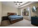 Comfortable bedroom featuring a tray ceiling, ceiling fan, and a large window for natural light at 1434 Pacific Rd, Kissimmee, FL 34759