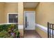 Close-up view of the home entrance featuring a well-lit entryway, garden, and modern white door at 1434 Pacific Rd, Kissimmee, FL 34759