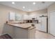 The well-lit kitchen includes white cabinets, stainless steel appliances, and a breakfast bar at 1434 Pacific Rd, Kissimmee, FL 34759