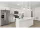 Modern kitchen features white cabinets, stainless steel appliances, and a center island with quartz countertops at 14905 Sw 39Th Cir, Ocala, FL 34473