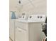 Laundry room with a washer, dryer, ironing board, and a shelf at 1606 Lima Ave, Kissimmee, FL 34747