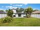 Landscaped backyard showcasing a lawn, patio, palm tree and exterior of the home with sliding glass doors at 1615 W Gadsen Blvd, Orlando, FL 32812