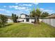 Image showing the green backyard, fence, palm trees and patio area with outdoor seating and a grill at 1615 W Gadsen Blvd, Orlando, FL 32812