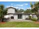 View of the backyard featuring a patio, green lawn, and the exterior of the home with sliding glass doors at 1615 W Gadsen Blvd, Orlando, FL 32812