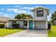 Charming home featuring a two-story accent, gray paint and a vibrant blue front door at 1615 W Gadsen Blvd, Orlando, FL 32812