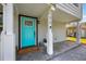 Inviting front porch featuring a vibrant blue door, gray pavers and white columns at 1615 W Gadsen Blvd, Orlando, FL 32812
