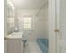 This bathroom features white-tiled walls and floors and a blue toilet and bathtub at 1621 Sunnyside Dr, Maitland, FL 32751