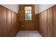 This cozy den showcases wood paneled walls, a window with shutters and white tile flooring at 1621 Sunnyside Dr, Maitland, FL 32751
