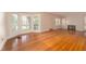 Open living room featuring hardwood floors, large bay window, and cozy fireplace at 1621 Sunnyside Dr, Maitland, FL 32751