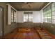 Inviting sunroom featuring wood paneling, ceiling fan, and multiple windows at 1621 Sunnyside Dr, Maitland, FL 32751