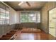 Cozy sunroom with wood paneling, ceiling fan, and ample natural light at 1621 Sunnyside Dr, Maitland, FL 32751
