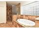 Bathroom with tiled shower and separate soaking tub with glass block window at 1653 Cheyenne Trl, Maitland, FL 32751