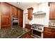 Well-equipped kitchen with stainless steel appliances, dark wood cabinets, and designer tile backsplash at 1653 Cheyenne Trl, Maitland, FL 32751