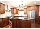 Cozy kitchen featuring dark wood cabinetry, granite counters, modern appliances, and a stainless steel refrigerator at 1653 Cheyenne Trl, Maitland, FL 32751