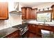 Chef's kitchen with granite counters, herringbone backsplash, stainless appliances, and gas range at 1653 Cheyenne Trl, Maitland, FL 32751