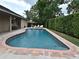 A lovely in-ground pool is surrounded by a well-manicured lawn and brick patio and has outdoor seating at 1653 Cheyenne Trl, Maitland, FL 32751