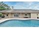 Exterior view of the in-ground pool with a brick patio, an outdoor dining area, and a grill at 1653 Cheyenne Trl, Maitland, FL 32751