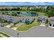 Aerial view of home, pond, and community featuring lush lawns and well-maintained landscaping at 17319 Million Lakes Ct, Clermont, FL 34714