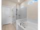 Bathroom features a glass-enclosed shower, a soaking tub, and neutral tiling at 17319 Million Lakes Ct, Clermont, FL 34714