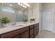 Bathroom with double sinks, quartz countertops, and a large mirror in a modern setting at 17319 Million Lakes Ct, Clermont, FL 34714