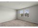 Bright, carpeted bedroom featuring double windows offering pleasant neighborhood views at 17319 Million Lakes Ct, Clermont, FL 34714