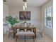Stylishly decorated dining area with a wooden table, striped seating, and a large black and white art piece at 17319 Million Lakes Ct, Clermont, FL 34714