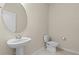 Half bathroom with pedestal sink and oval mirror at 17319 Million Lakes Ct, Clermont, FL 34714