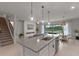 Modern kitchen with center island, stylish pendant lighting, and adjacent living area with outdoor views at 17319 Million Lakes Ct, Clermont, FL 34714