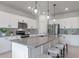 Modern kitchen featuring a large island with pendant lights, stainless steel appliances, and sleek white cabinetry at 17319 Million Lakes Ct, Clermont, FL 34714