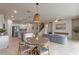 Open-concept living space with modern kitchen, dining area and cozy seating arrangement by the fireplace at 17319 Million Lakes Ct, Clermont, FL 34714