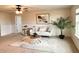 Bright living room showcasing a plush sofa, stylish rug, modern art, and a potted palm at 17319 Million Lakes Ct, Clermont, FL 34714