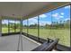 Relaxing screened patio featuring a porch swing and views of a large green lawn at 17319 Million Lakes Ct, Clermont, FL 34714