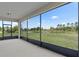 Screened patio offering serene views of the backyard, lake, and lush landscape at 17319 Million Lakes Ct, Clermont, FL 34714
