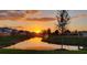 Scenic sunset view of the pond in the community with trees and new construction homes visible at 17319 Million Lakes Ct, Clermont, FL 34714