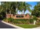 Landscaped entrance to The Villas at Chase Groves with brick sign and mature palm trees at 2011 Crestdale Ln, Lake Mary, FL 32746