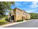 Exterior view of tan townhome featuring screened in patio and lush landscaping at 2011 Crestdale Ln, Lake Mary, FL 32746